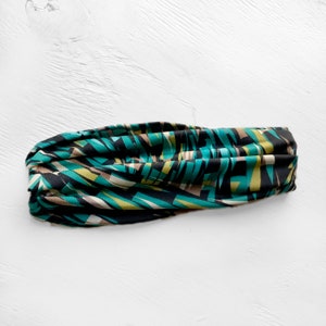 Puede incluir: Una diadema con estampado geom&eacute;trico en negro, verde y marr&oacute;n.