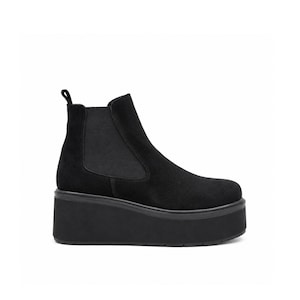 May include: A black suede Chelsea boot featuring a high platform sole, elastic side panels, and a small pull tab at the heel. The shoe has a rounded toe and a thick, solid black rubber outsole that provides significant elevation.
