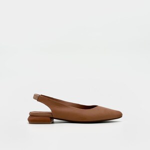 May include: A single brown leather slingback flat shoe with a square toe and a small, stacked heel. The shoe has a strap that goes around the back of the ankle. The shoe is set against a white background.