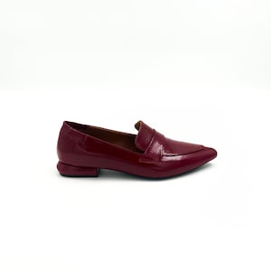 May include: Burgundy leather loafers with a pointed toe and a small heel.