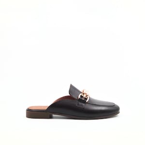 Può includere: Mocassino in pelle nera con dettaglio catena color oro sulla tomaia. La scarpa ha una punta arrotondata e un tacco basso. Il design aperto sul retro offre uno stile slip-on. La suola è marrone.