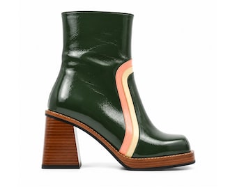 May include: A dark green patent leather ankle boot with a square toe and a high, thick, wood-grain block heel. The side of the boot features a curved, vertical stripe detail in light peach and cream colors, set against the glossy green finish.