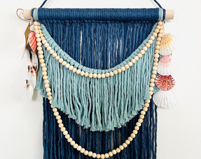 Tapiz de macramé estilo marino con cuentas y conchas. Decoración de pared boho costera.