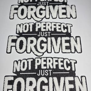 May include: Three black and white patches with the text "NOT PERFECT JUST FORGIVEN". The text is in a bold, stylized font with a fuzzy, textured appearance. The patches are rectangular with rounded corners.