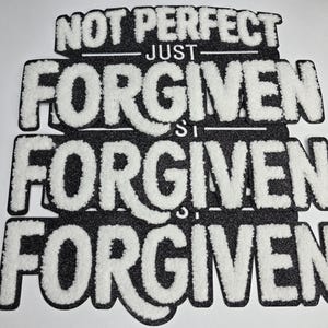May include: Black and white patch with the words "NOT PERFECT JUST FORGIVEN" in a layered design. The text is in a bold, textured font, with the word "FORGIVEN" repeated three times.
