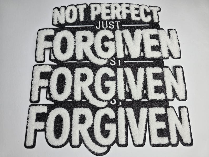 May include: Black and white patch with the words "NOT PERFECT JUST FORGIVEN" in a layered design. The text is in a bold, textured font, with the word "FORGIVEN" repeated three times.