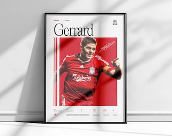 May include: Framed poster featuring Steven Gerrard in a red Liverpool FC jersey. The poster has a red background with white vertical stripes and the name "Gerrard" in large black letters. Includes the Liverpool FC logo and player statistics.