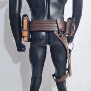 Puede incluir: Un cintur&oacute;n utilitario de cuero marr&oacute;n con m&uacute;ltiples bolsas y una funda para la pierna. El cintur&oacute;n se lleva alrededor de la cintura y tiene un cierre de hebilla. Las bolsas son de varios tama&ntilde;os y formas, y la funda para la pierna est&aacute; sujeta con una correa.