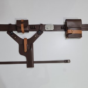 Puede incluir: Un cintur&oacute;n utilitario de cuero marr&oacute;n con bolsas, una funda y un cintur&oacute;n a juego. El cintur&oacute;n tiene una hebilla plateada y est&aacute; dise&ntilde;ado para transportar objetos. Las bolsas y la funda est&aacute;n aseguradas con correas color canela.