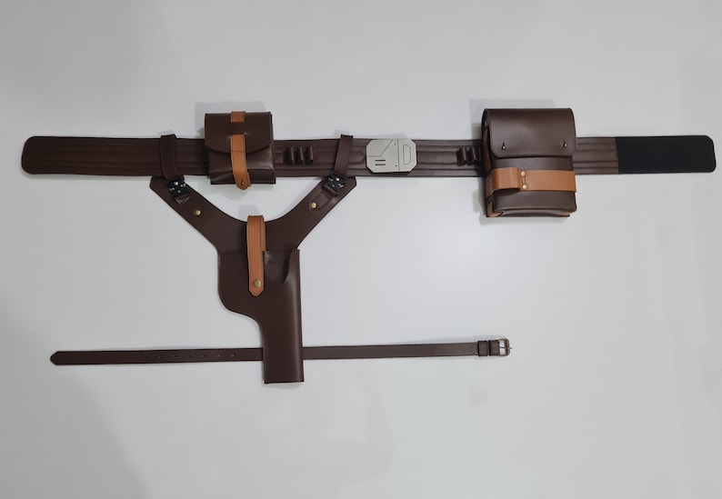 Puede incluir: Un cintur&oacute;n utilitario de cuero marr&oacute;n con bolsas, una funda y un cintur&oacute;n a juego. El cintur&oacute;n tiene una hebilla plateada y est&aacute; dise&ntilde;ado para transportar objetos. Las bolsas y la funda est&aacute;n aseguradas con correas color canela.