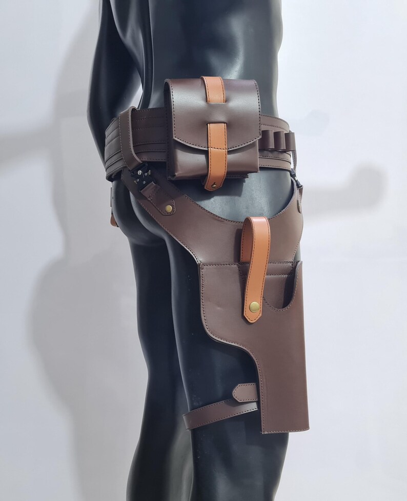 Puede incluir: Juego de cintur&oacute;n y funda de cuero marr&oacute;n. El conjunto incluye un cintur&oacute;n con una bolsa y portacartuchos, y una funda para la pierna. El cuero es de un marr&oacute;n intenso con detalles en beige.