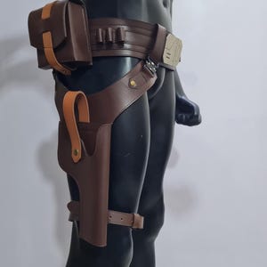 Puede incluir: Un cintur&oacute;n utilitario de cuero marr&oacute;n con una funda, una bolsa y portacartuchos. El cintur&oacute;n presenta un acento marr&oacute;n claro en la bolsa y la funda. El cintur&oacute;n se asegura con una hebilla y una correa para la pierna.