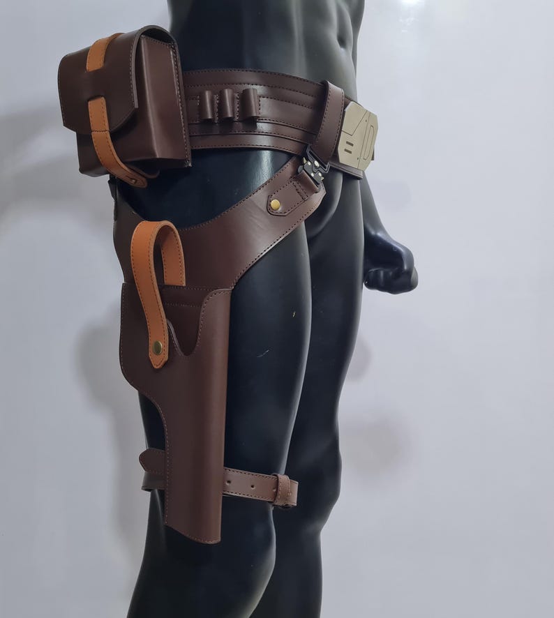 Puede incluir: Un cintur&oacute;n utilitario de cuero marr&oacute;n con una funda, una bolsa y portacartuchos. El cintur&oacute;n presenta un acento marr&oacute;n claro en la bolsa y la funda. El cintur&oacute;n se asegura con una hebilla y una correa para la pierna.