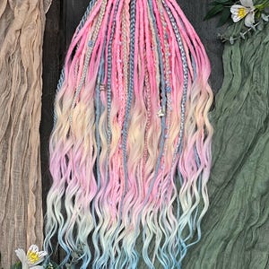 May include: A set of colorful dreadlocks in shades of pink, blue, and blonde. The dreadlocks are styled with a mix of braids and loose, wavy ends. Some dreadlocks are adorned with small beads. The overall effect is a vibrant and whimsical hairstyle.