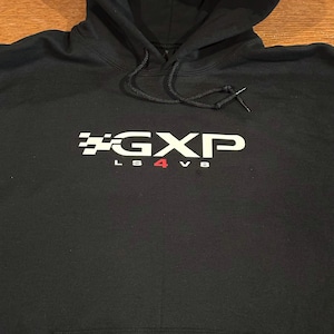 May include: Black hooded sweatshirt with a white graphic of the text "GXP LS4 V8" with a chequered flag design.