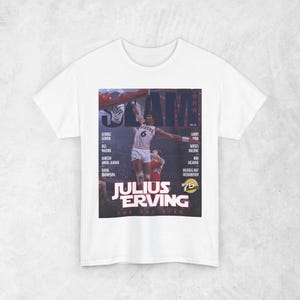 May include: White t-shirt featuring a vintage magazine cover with Julius Erving, number 6, in action. The image includes the text "SLAM" and "JULIUS ERVING THE ONE STAR" with a list of names. A retro sports-themed tee.