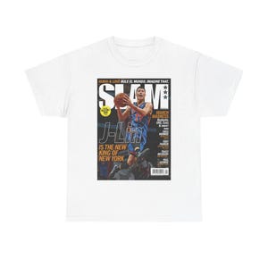 May include: White t-shirt featuring a magazine cover with a basketball player in a blue and orange uniform. The magazine cover reads "SLAM" and "J-Lin IS THE NEW KING OF NEW YORK."