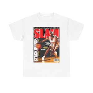 May include: White t-shirt featuring a magazine cover design. The cover has the word "SLAM" in large red letters, with a basketball player in action. Text includes "STACKHOUSE" and "March Madness: Kentucky, Experts Final 8 & more".