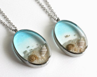 Clear Blue Seashell and Beach Sand Oval Pendant Necklace