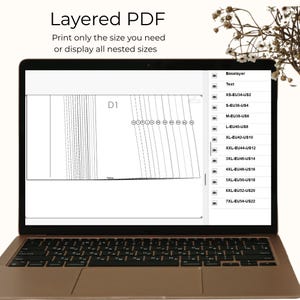Puede incluir: Una pantalla de port&aacute;til que muestra un patr&oacute;n de costura PDF en capas con el texto Layered PDF, Print only the size you need or display all nested sizes. La interfaz muestra una lista de tallas desde XS-EU34-US2 hasta 7XL-EU54-US22.
