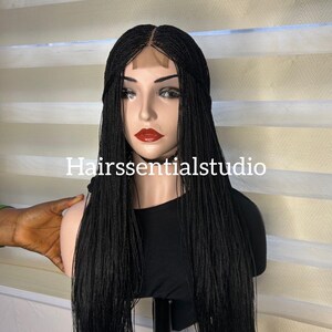 May include: Black micro braid wig with a lace closure. The wig is styled in long, straight braids.