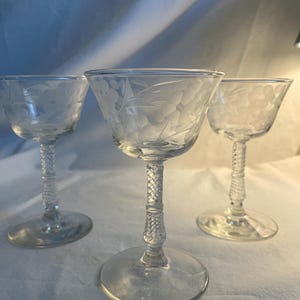 Juego de tres copas de cóctel con flores grabadas.