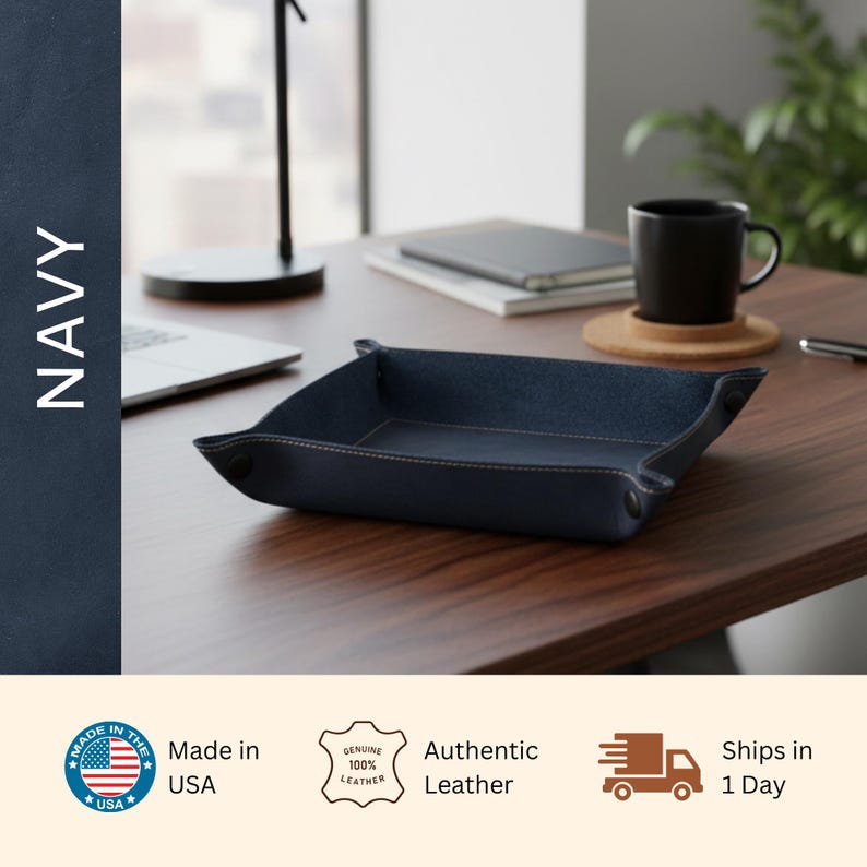 a navy blue leather tray on a wooden desk, with a laptop, notebook, and coffee cup nearby.