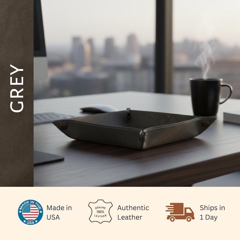 a grey leather desk tray placed on a wooden desk, with a cup of coffee nearby.
