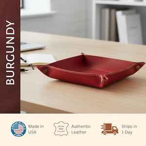 a burgundy leather desk organizer on a wooden desk, with a laptop and other office supplies visible in the background.