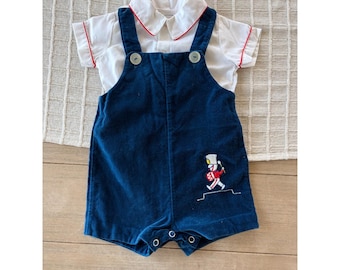 Vintage Baby Jungen Blauer Strampler aus Velour mit einem Trommler Jungen Applikation.