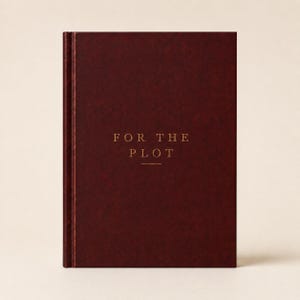 May include: A dark burgundy hardcover journal with a textured finish. The front cover features the gold-colored text "FOR THE PLOT" centered in the middle, with a small horizontal line underneath the word "PLOT" in a clean, serif typeface.