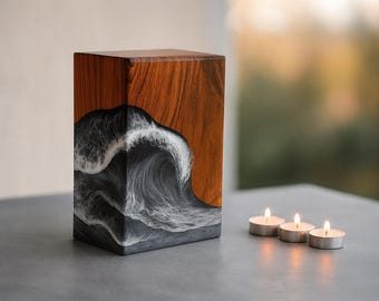 May include: A wooden rectangular decorative box with a wave design. The box has a dark wood grain top and a wave design in shades of gray and white. Three lit tea light candles are in front of the box.