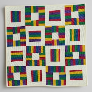 May include: A square quilt with a cream-colored background and a repeating pattern of colorful blocks. The blocks feature stripes of red, orange, yellow, green, and purple. The quilt is machine-stitched with a quilted design.
