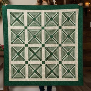 Può includere: Una trapunta verde e crema con un motivo geometrico. La trapunta presenta un motivo ripetuto di quadrati e rettangoli verdi, con un bordo verde pieno. La trapunta è realizzata in un materiale morbido e trapuntato.