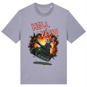 Puede incluir: Camiseta de color lila claro con una ilustración de dibujos animados. Muestra un tanque verde con una rata encima, sobre un fondo de explosión. El texto "HELL YEAH!" está encima del tanque en letras rosas.