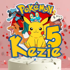 May include: A cake topper featuring the word "Pok&eacute;mon" above a collection of cartoon characters, including Pikachu. The number "5" and the name "Kezie" are also displayed. The design is set against a pink background with red confetti.