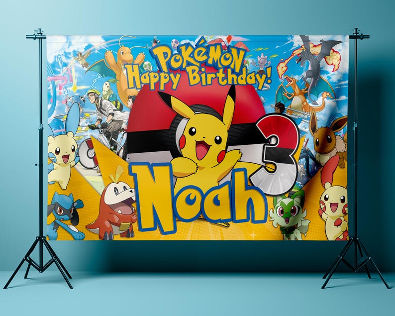 May include: A colorful birthday banner featuring the Pok&eacute;mon characters Pikachu, Charizard, and Eevee. The banner has the text "Pok&eacute;mon Happy Birthday!" and the name "Noah" with the number "3". The background is a blue sky with clouds.