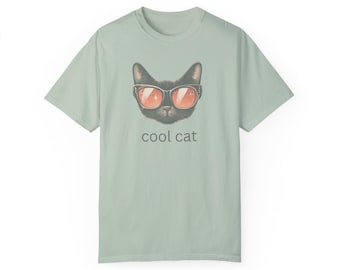 May include: A light green t-shirt with a black cat wearing sunglasses and the text "cool cat" printed on the front.