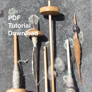 May include: Five different wooden spinning wheels with various colors of yarn and fiber. The spinning wheels are on a gray surface.  PDF Tutorial Download.