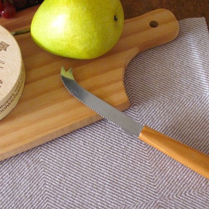A brown and white Twill Block patterned hand woven towel, shown as an example for Table or Floor Loom Weaving Pattern Draft PDF, 4 H Harness Shaft Handweaving Cotton Kitchen Hand Woven Dish Tea Towel Downloadable Tutorial, an artful Kitchenware, Cookware Accessory for Gourmet Chef, Home Baking, Cooking, Instructions Designed by Master Weaver Amy C. Lund. Pictured with with a cheese knife, pear, grapes and cheese on a wooden cutting board.