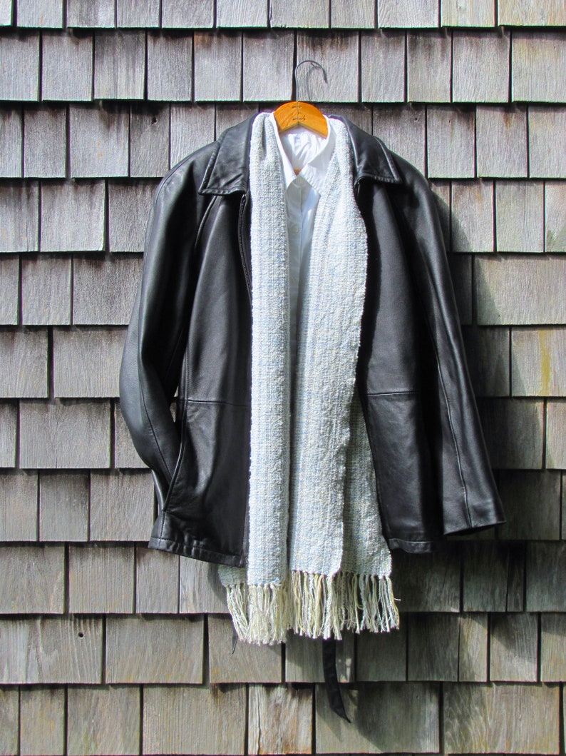 Handmade Light Blue Chalcedony Artisan Hand Woven Scarf Shawl or Table Runner for Positive Natural Energy, Spiritual Serenity, Harmony, Grounding Meditation Prayer is a Gender Neutral Unisex Men's Women's Long Fall, Winter, Spring, Urban Casual Rustic Fashion Accessory Wrap or Home Decor Accent Handcrafted by Amy C. Lund in Cotton Blend. Styled with a black leather coat.