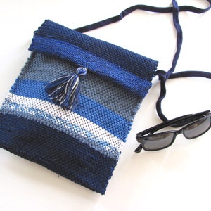 Small Crossbody Bag Wallet or Phone Purse is Handmade, Artisan Hand Woven in Indigo Navy Blue with Zero Waste, Eco Friendly Upcycled Cloth, Vegan Recycled Fabric. This Sustainable Slow Fashion Accessory Handbag, Boho Cash Change Pouch or Money Shoulder Pouch is Handcrafted by Amy C. Lund. Styled casually with black sunglasses.