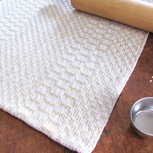 Handcrafted Butter Cream Artisan Hand Woven Cotton Kitchen Dish Towel, Gourmet Chef Gift or Home Cooking Baking Gift, Rustic Country French Cottage Modern Farmhouse Cookware or Kitchenware Decor Accessory.  Styled with a metal measuring cup. a wooden rolling pin, oats.