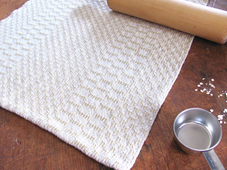 Handcrafted Butter Cream Artisan Hand Woven Cotton Kitchen Dish Towel, Gourmet Chef Gift or Home Cooking Baking Gift, Rustic Country French Cottage Modern Farmhouse Cookware or Kitchenware Decor Accessory.  Styled with a metal measuring cup. a wooden rolling pin, oats.