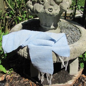 Artisan Handmade Light Blue Spring Summer Scarf, Minimalist Zen Serenity, Simplicity, Soothing Tranquil Tones Meditation Table Runner, Gender Neutral Unisex Men's or Women's Om Yoga, Spiritual Prayer Clothing, Hand Woven Cotton Scarf, Slow Fashion Accessory or Home Decor Accent Gift Idea. Styled casually on a garden sculpture.