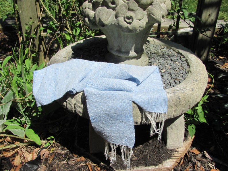 Artisan Handmade Light Blue Spring Summer Scarf, Minimalist Zen Serenity, Simplicity, Soothing Tranquil Tones Meditation Table Runner, Gender Neutral Unisex Men's or Women's Om Yoga, Spiritual Prayer Clothing, Hand Woven Cotton Scarf, Slow Fashion Accessory or Home Decor Accent Gift Idea. Styled casually on a garden sculpture.