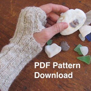 May include: A close-up of a knitted fingerless glove in a light beige color. The glove is made with a textured stitch pattern. The text "PDF Pattern Download" is visible in the image.