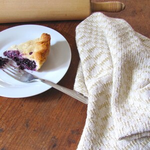 Handcrafted Butter Cream Artisan Hand Woven Cotton Kitchen Dish Towel, Gourmet Chef Gift or Home Cooking Baking Gift, Rustic Country French Cottage Modern Farmhouse Cookware or Kitchenware Decor Accessory.  Styled with a wooden rolling pin, slice of blueberry pie on a white plate with a fork.