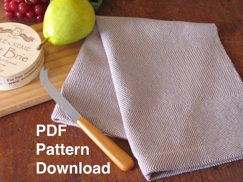 A brown and white Twill Block patterned hand woven towel, shown as an example for Table or Floor Loom Weaving Pattern Draft PDF, 4 H Harness Shaft Handweaving Cotton Kitchen Hand Woven Dish Tea Towel Downloadable Tutorial, an artful Kitchenware, Cookware Accessory for Gourmet Chef, Home Baking, Cooking, Instructions Designed by Master Weaver Amy C. Lund. Pictured with with a cheese knife, pear, grapes and cheese on a wooden cutting board. The text below the image reads 'PDF Pattern Download'.