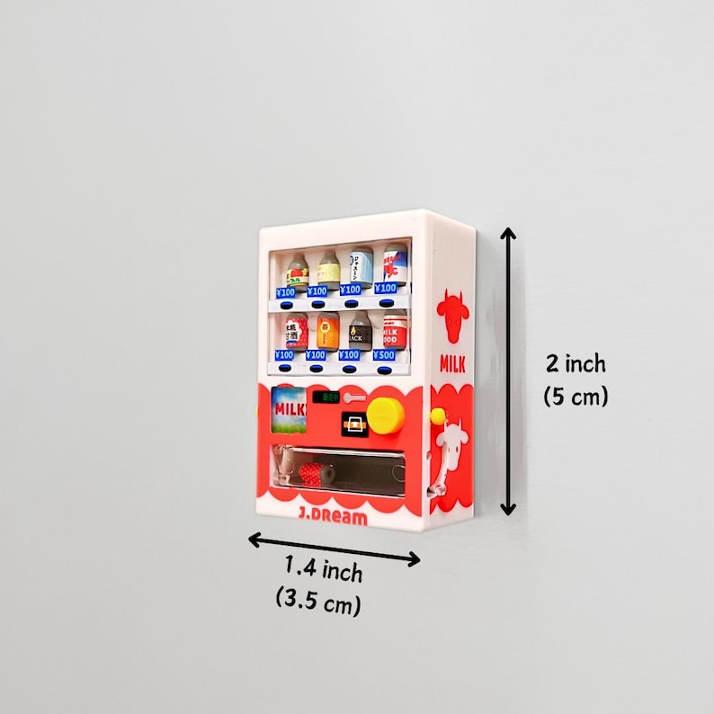 May include: A miniature white vending machine with red and blue accents, featuring various small product replicas. The machine is 2 inches (5 cm) tall and 1.4 inches (3.5 cm) wide, with the text "MILK" and "J.dream" visible.